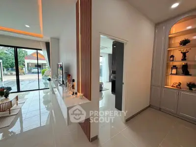 Modern open-plan living area with sleek design and large windows offering garden views.