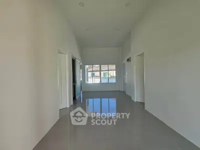 Spacious modern room with glossy tiled floor and large window view.