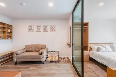 Modern living room with cozy sofa and stylish bedroom in open layout apartment.