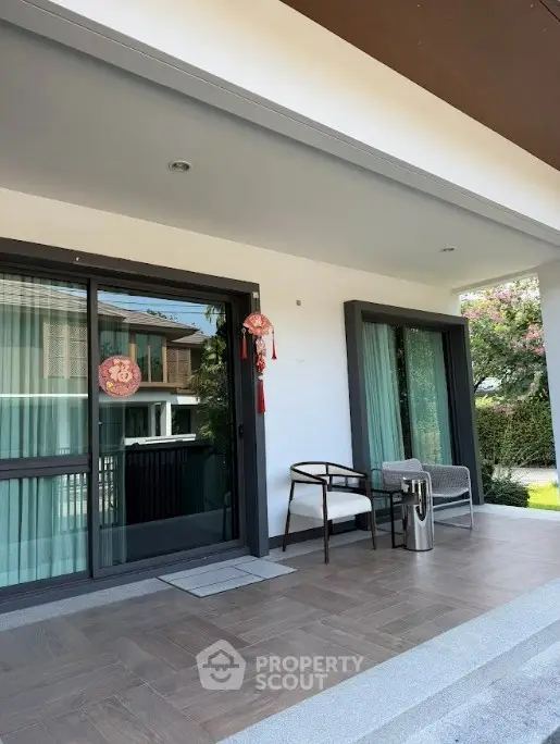 Modern house entrance with stylish patio furniture and decorative accents.