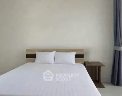 Minimalist bedroom with wooden headboard and white bedding