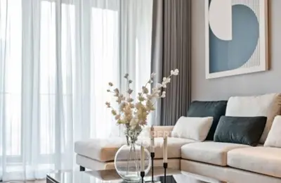 Elegant modern living room with stylish decor and large windows.