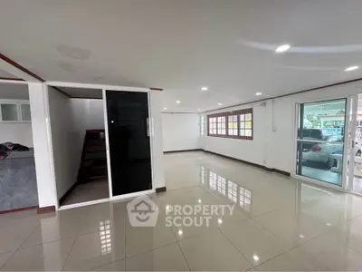 Spacious modern living room with glossy tile flooring and large windows