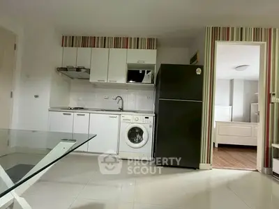 Modern kitchen with washing machine and fridge in open layout apartment