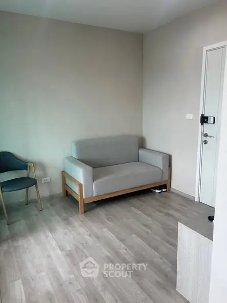 Modern minimalist living room with light wood flooring and neutral furniture.