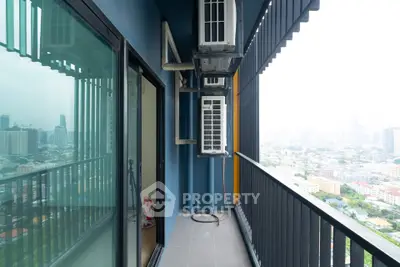 Spacious balcony with city view and air conditioning units in a modern high-rise apartment.