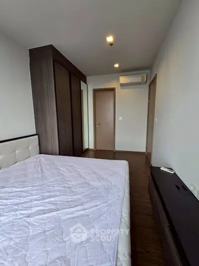 Spacious bedroom with modern wardrobe and air conditioning in a stylish apartment.