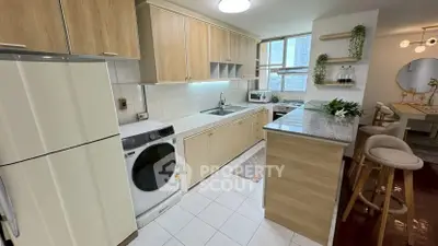 Modern kitchen with open layout and dining area, featuring sleek appliances and stylish decor.