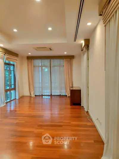 Spacious living room with hardwood floors and large windows for natural light.