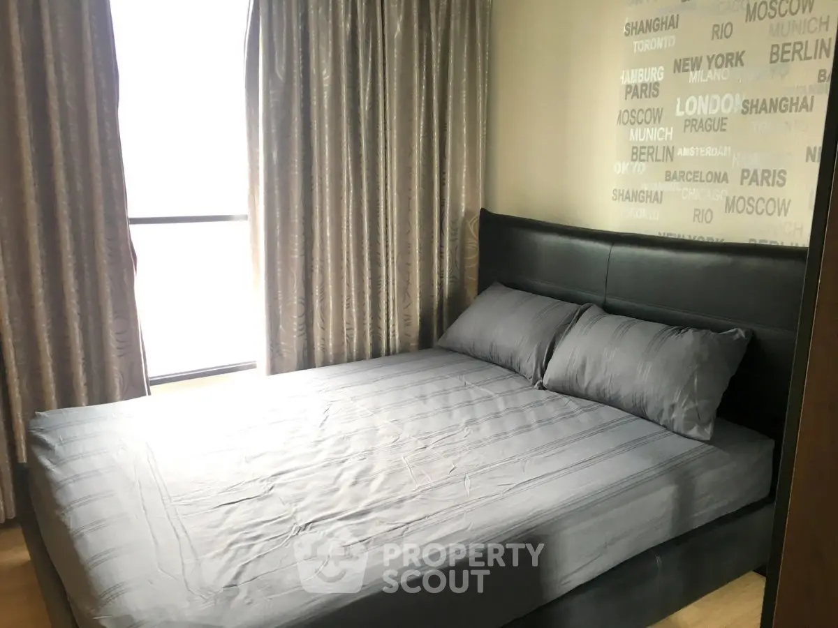 Modern bedroom with stylish decor and city-themed wallpaper, featuring a comfortable bed and elegant curtains.