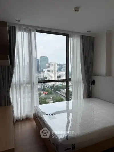 Modern bedroom with city view and large windows in high-rise apartment
