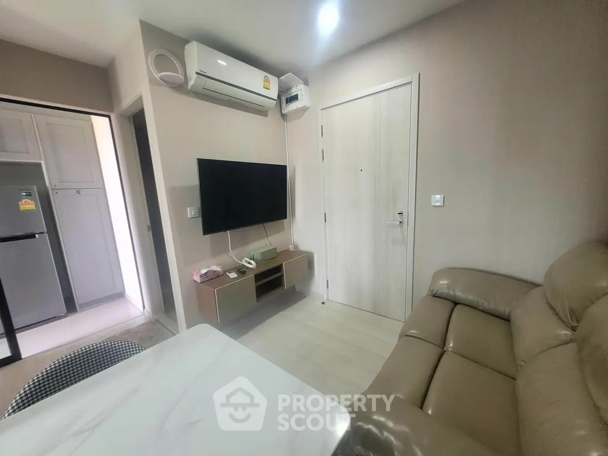 Cozy living room with modern furniture and wall-mounted TV in a stylish apartment.