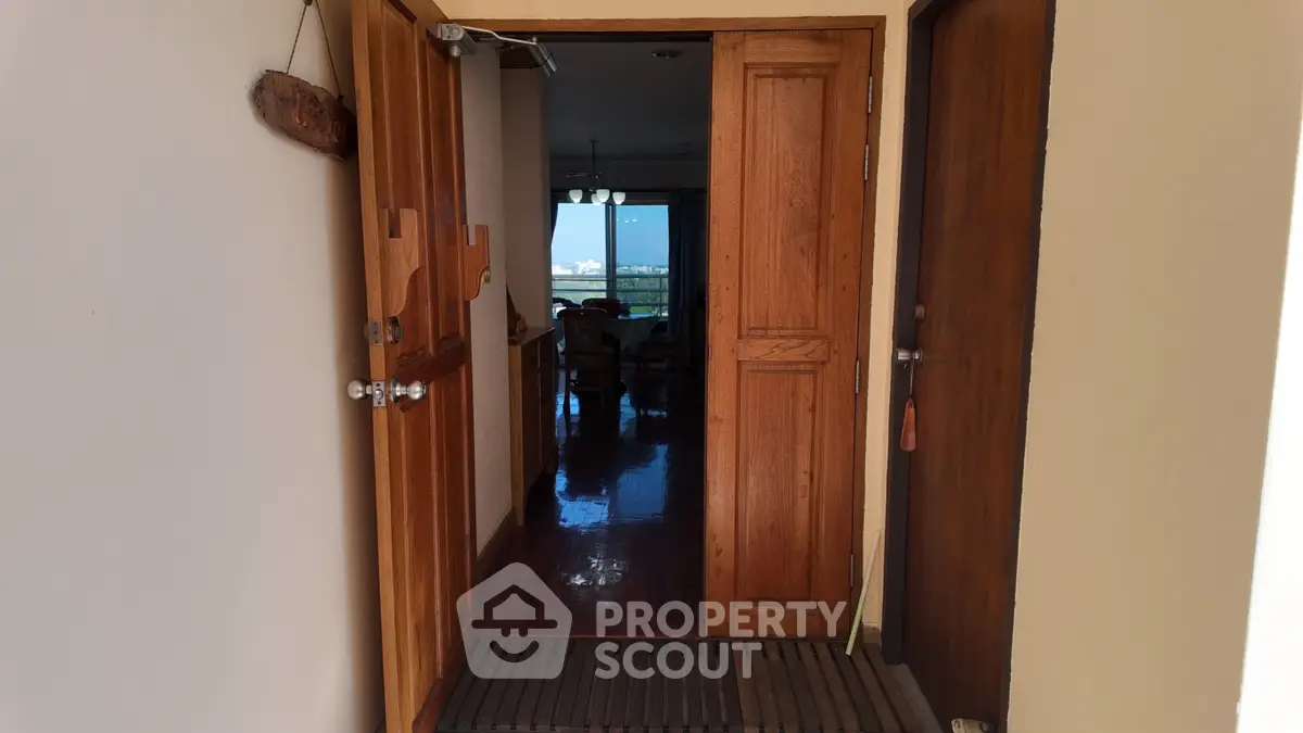 Inviting entrance to a cozy home with wooden doors and a glimpse of the interior.