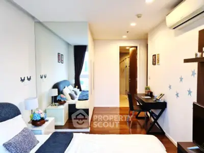 Modern bedroom with stylish decor and workspace, featuring hardwood floors and natural light.