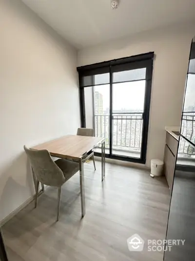 Modern dining area with balcony view in high-rise apartment