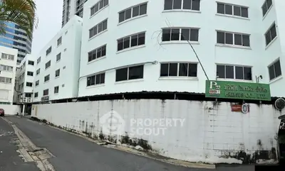 Modern white building exterior with multiple windows and a clean street view.