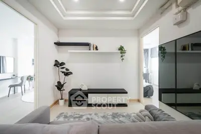 Modern living room with sleek design and minimalist decor, featuring a stylish shelving unit and cozy seating area.