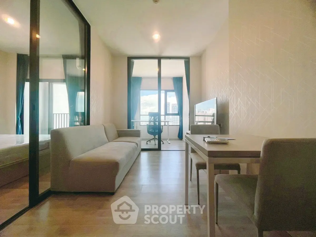 Modern apartment interior with glass partition, cozy living area, and natural light