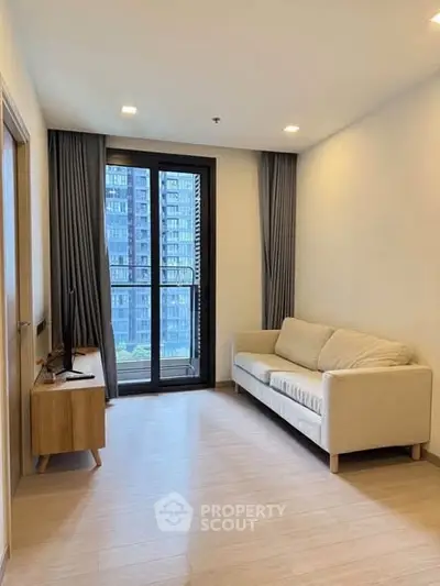 Modern living room with large window and cozy sofa in a high-rise apartment.