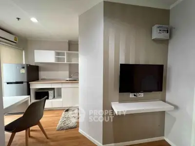 Modern apartment interior with open kitchen and cozy living area, featuring sleek furniture and appliances.