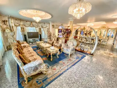 Luxurious living room with ornate furniture and elegant chandeliers, showcasing opulent interior design.