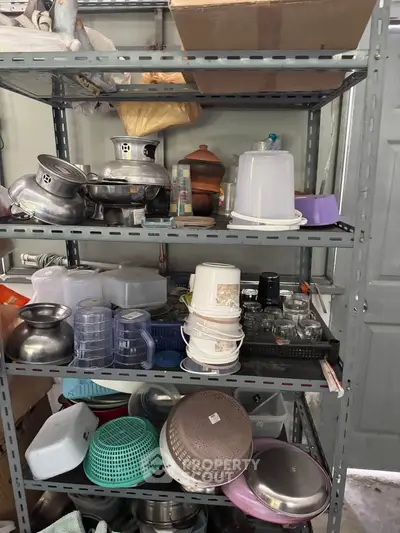 Organized storage room with metal shelves and various kitchen items neatly arranged.