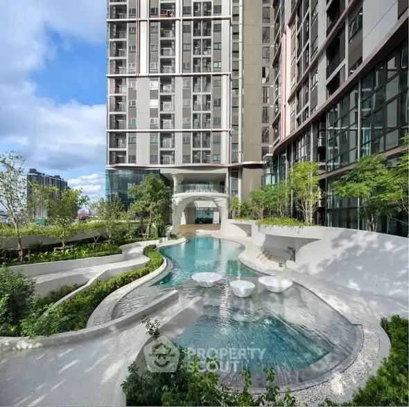 Luxurious modern apartment building with stunning pool and lush greenery, perfect for urban living.