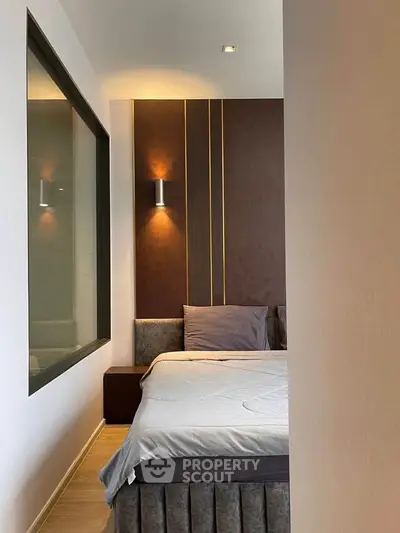 Modern bedroom with stylish lighting and cozy bed in contemporary apartment.