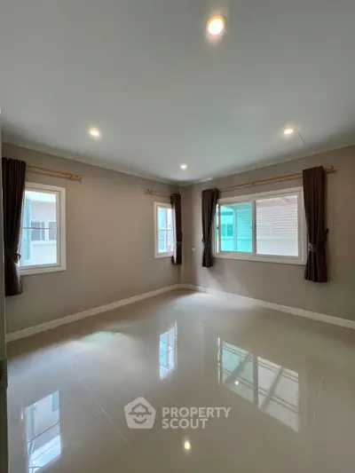Spacious empty room with large windows and glossy tiled floor, perfect for customization.