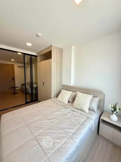 Modern bedroom with stylish decor and sliding glass doors in a contemporary apartment.