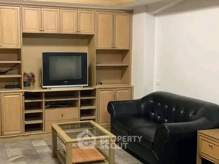 Cozy living room with classic wooden cabinetry and leather sofa