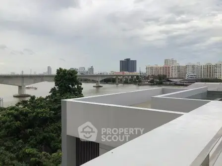 Stunning river view from modern rooftop terrace in urban setting.