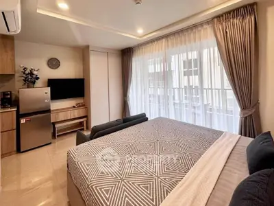 Modern bedroom with stylish decor and natural light, featuring a compact kitchen area.