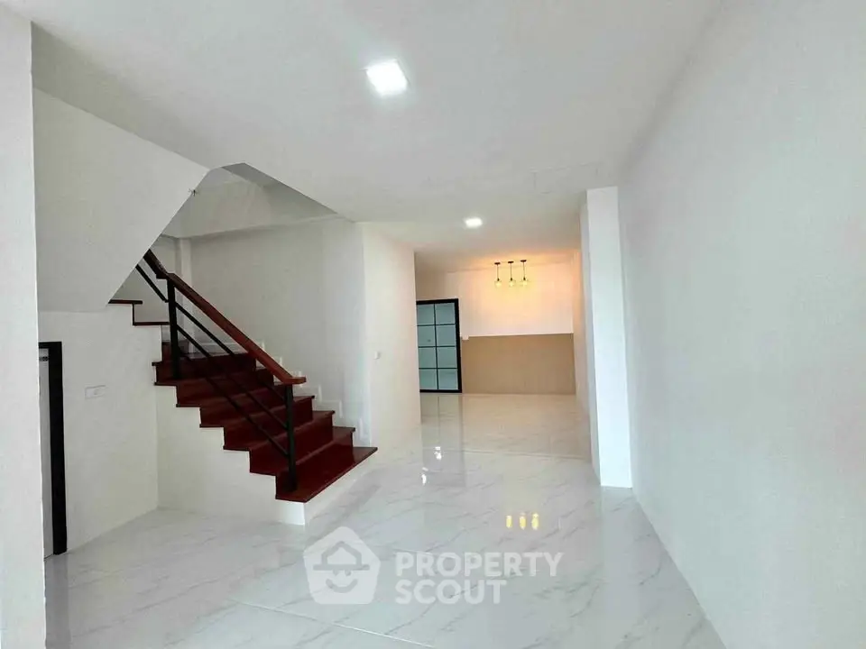 Spacious modern interior with elegant staircase and open layout, perfect for contemporary living.
