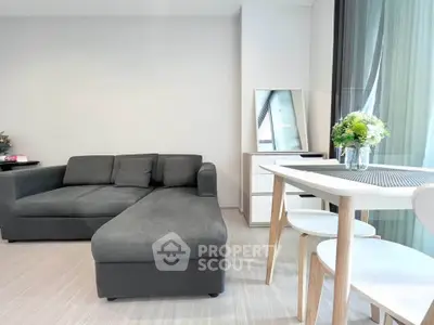 Modern living room with sleek gray sofa and elegant dining area, perfect for urban living.