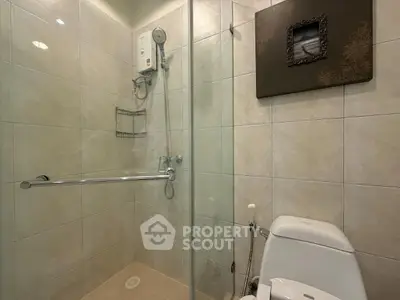 Modern bathroom with glass shower enclosure and sleek toilet design.