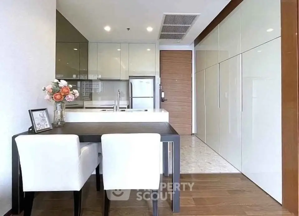 Modern kitchen with sleek cabinetry and dining area in a stylish apartment