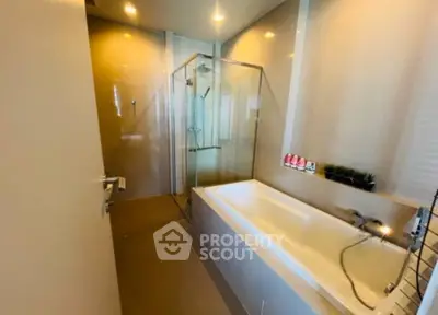 Modern bathroom with glass shower and bathtub in elegant design.