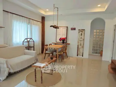 Charming living room with rustic decor and natural light, featuring cozy seating and a stylish dining area.