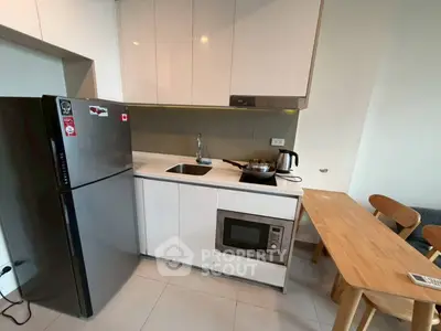 Modern compact kitchen with sleek appliances and dining area