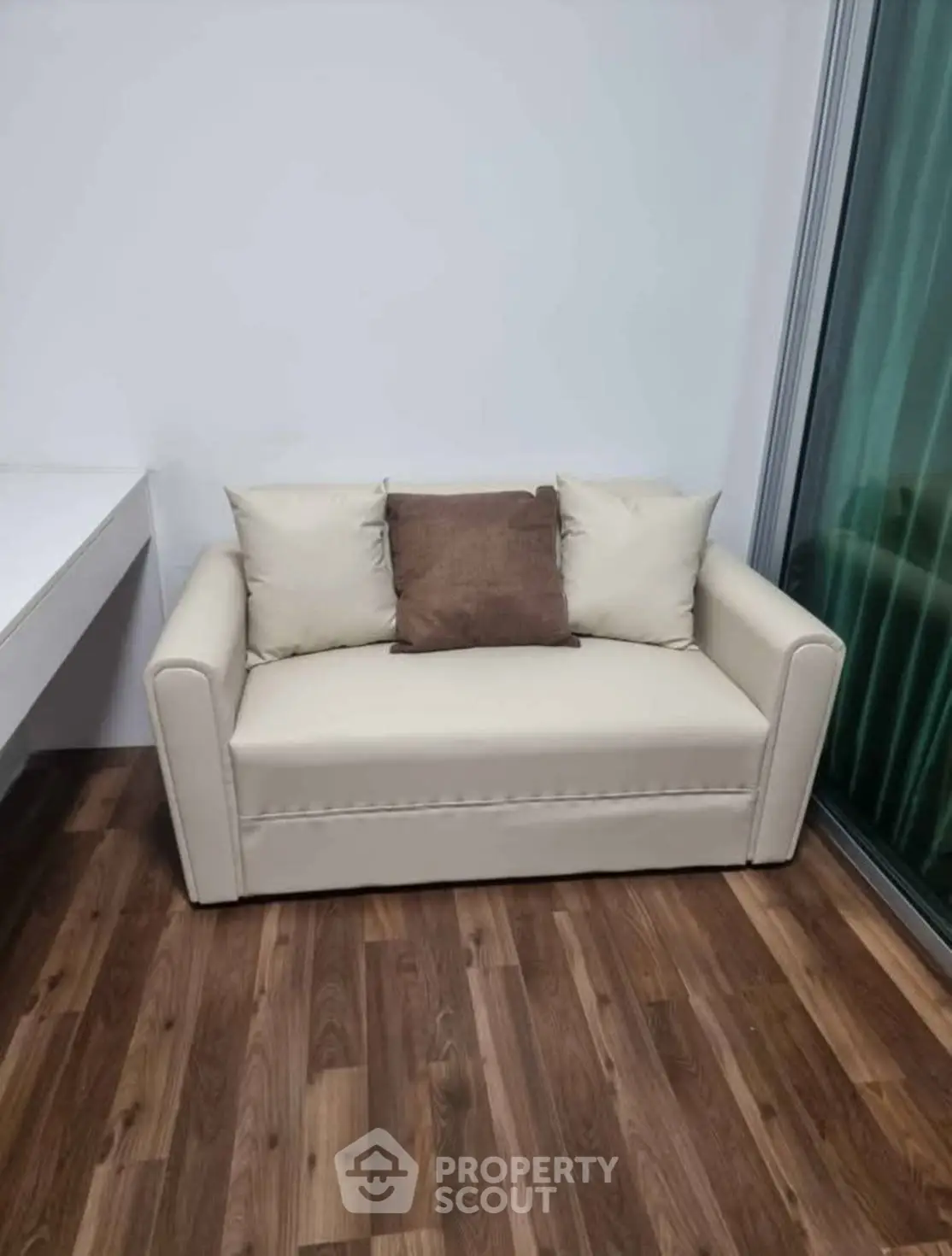 Cozy small living room with modern beige sofa and wooden flooring