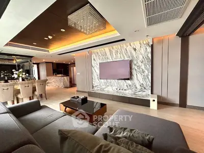 Luxurious modern living room with marble accent wall and open kitchen layout.