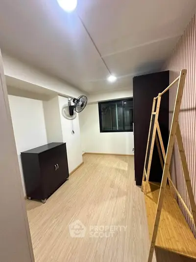 Spacious room with wooden flooring and modern furnishings, ideal for versatile use.