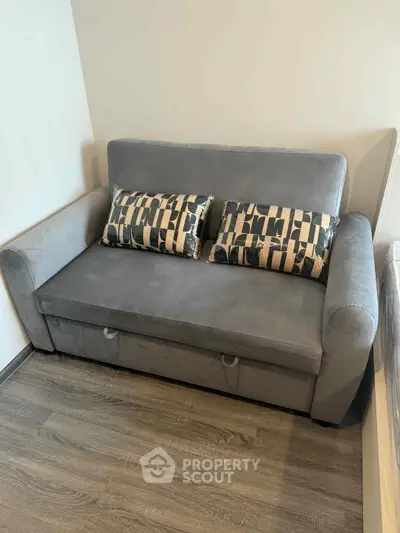 Cozy gray sofa with patterned cushions in a modern living room setting.