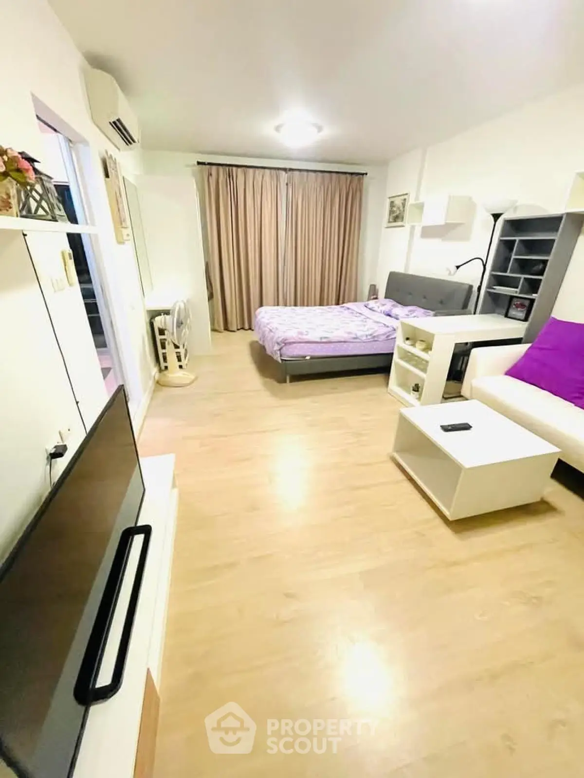 Spacious modern bedroom with wooden flooring and stylish decor