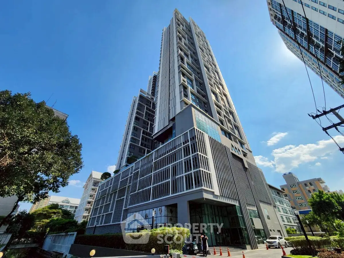 Stunning modern high-rise building with sleek architecture and lush greenery, perfect for urban living.