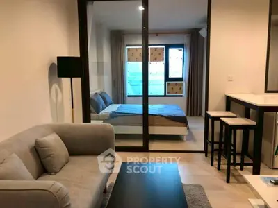 Modern open-plan living room with cozy seating and stylish bedroom view.
