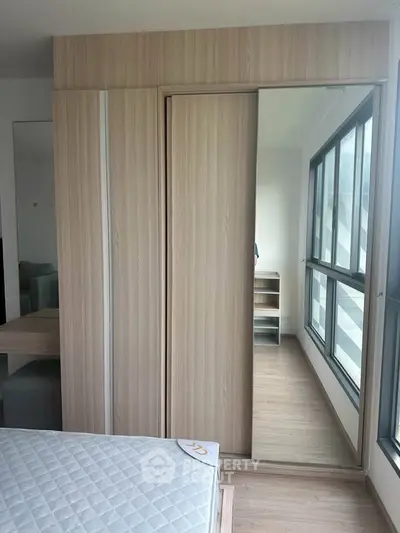 Modern bedroom with large windows and sleek wardrobe design.