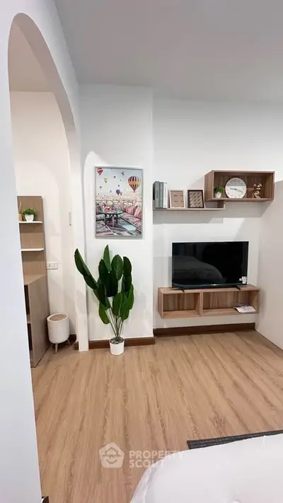 Modern living room with wooden flooring, stylish shelves, and a cozy atmosphere.