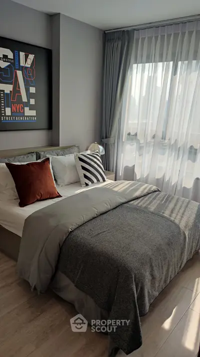 Modern bedroom with stylish decor and natural light, featuring cozy bedding and elegant curtains.